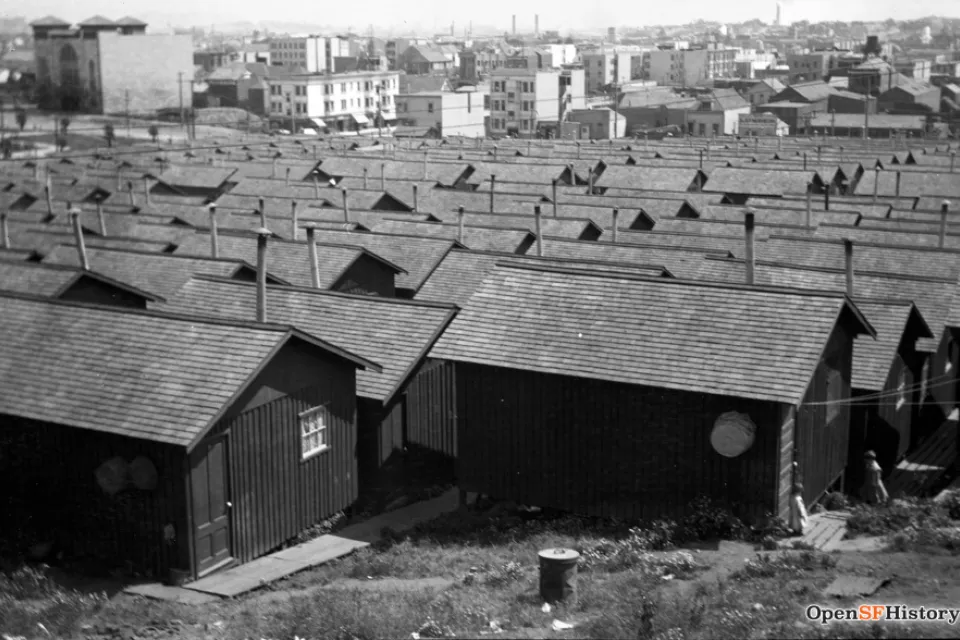 Black and white photo of refugee camp of small wood cottages in Dolores Park, San Francisco CA after 1906 earthquake.
